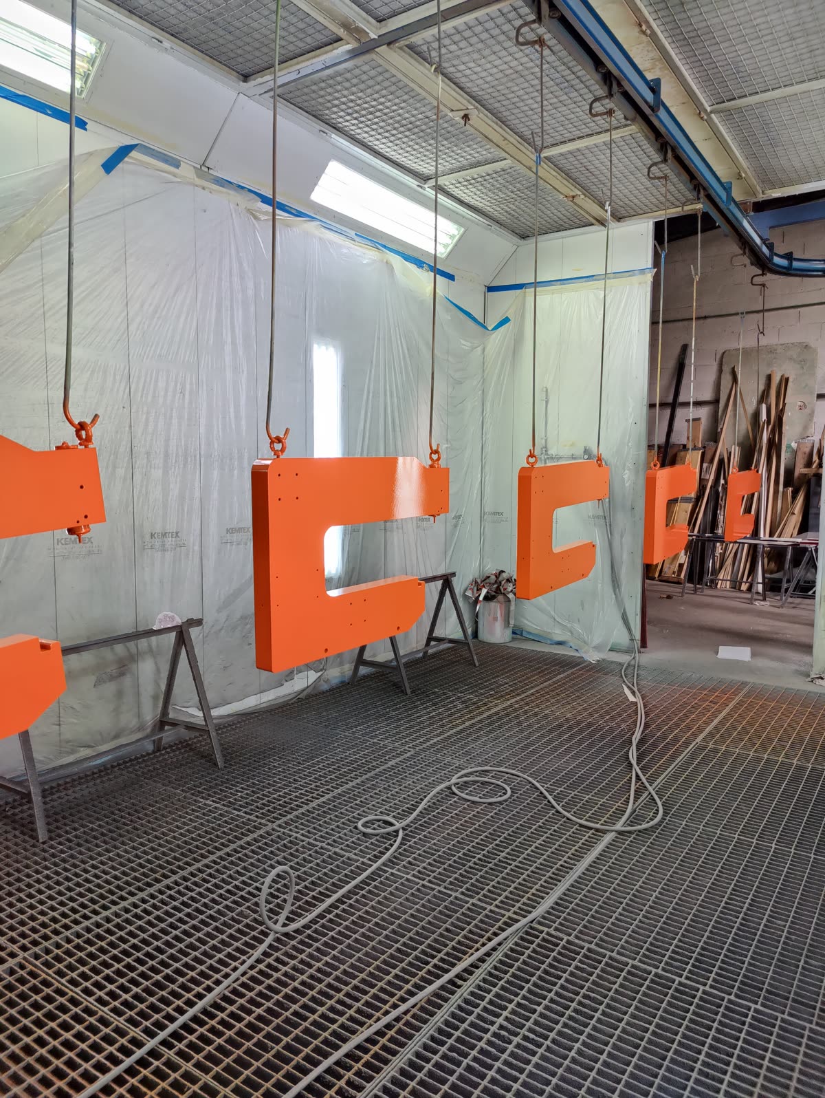 Pièces suspendues dans la cabine de peinture SIRPE